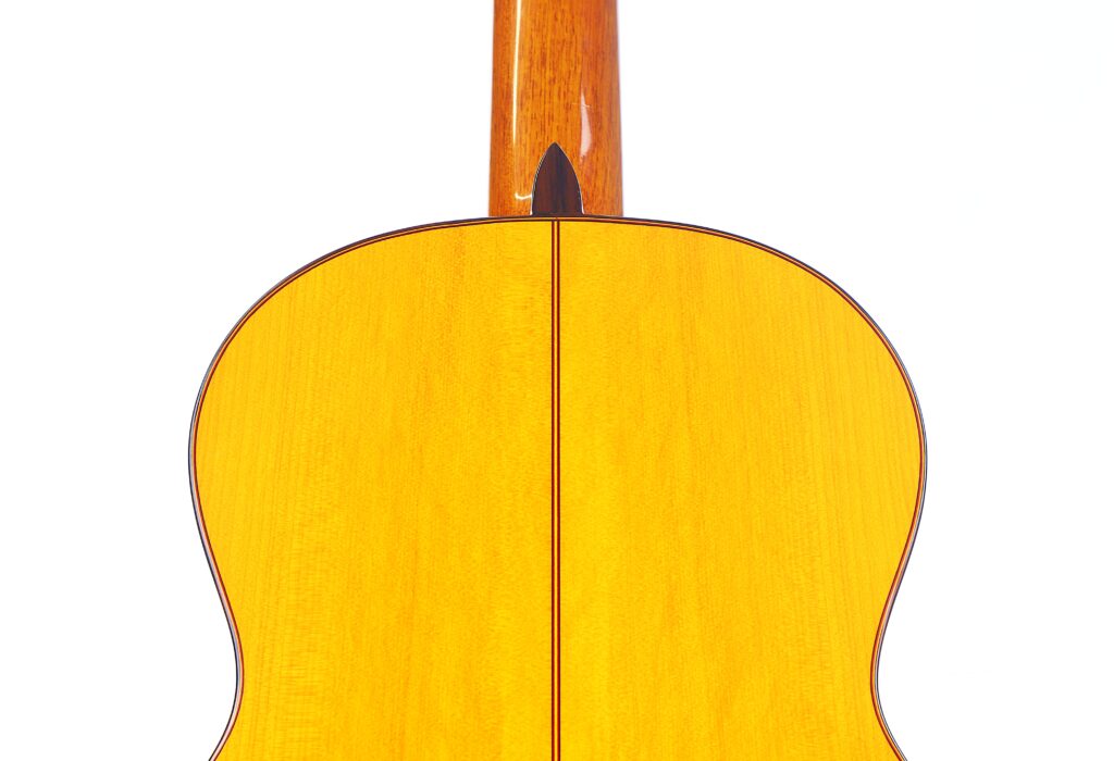 Nahaufnahme Der Rückseite Der Hermanos Sanchis Lopez F Especial 2025 Mod. Reyes Flamenco-Gitarre, Mit Glänzender Heller Holzoberfläche, Dunkler Mittelnaht Und Einem Oben Sichtbaren Teil Des Halses Vor Weißem Hintergrund.