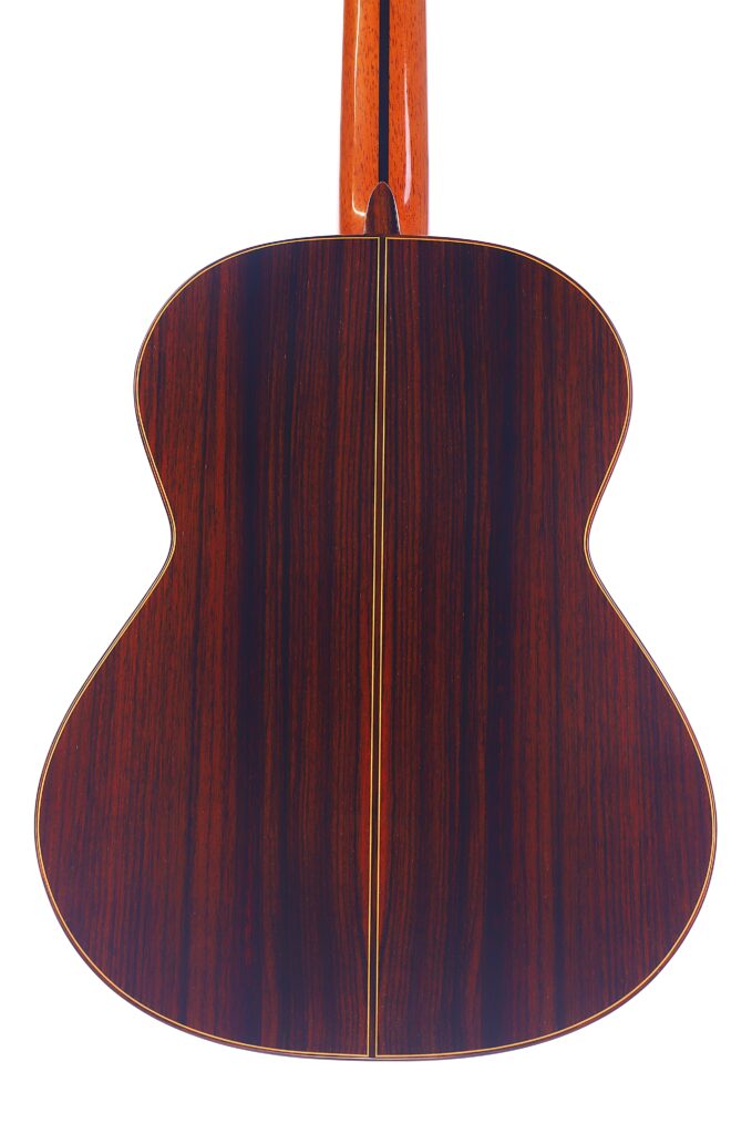 Die Rückansicht Der José Ramírez Rb-A 636 Klassische Gitarre Zeichnet Sich Durch Eine Polierte Dunkle Holzoberfläche, Eine Dünne Helle Mittelnaht Und Einen Rotbraunen Hals Aus.