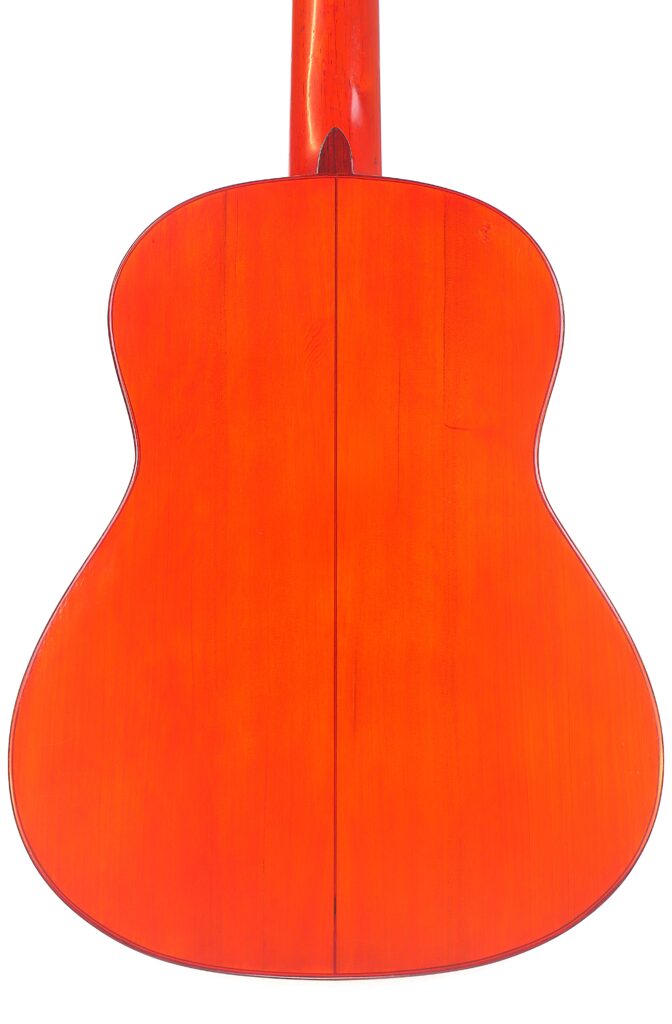 Die Abbildung Zeigt Die Rückseite Einer Faustino Conde Flamenco-Gitarre Von Hermanos Conde Aus Dem Jahr 1983. Sie Zeichnet Sich Durch Ein Symmetrisches Design Mit Einer Zentralen Naht Und Eine Glänzende Orangefarbene Lackierung Aus, Die Die Holzmaserung Hervorhebt.