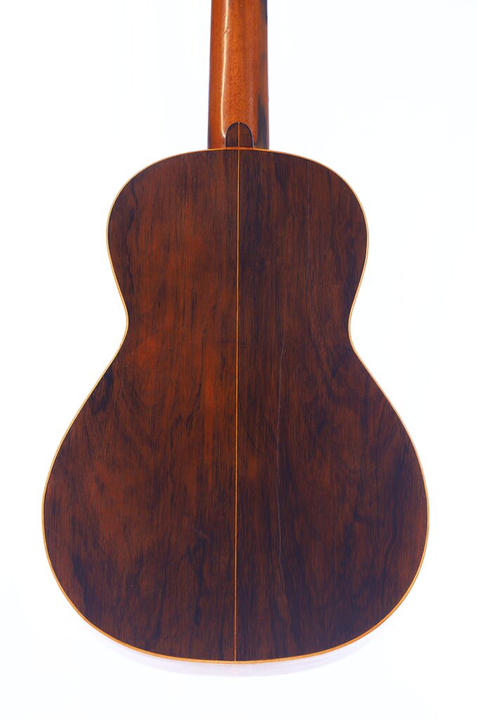 Das Bild Zeigt Die Rückseite Einer Julián Gómez Ramírez 1933 Klassische Gitarre Mit Einer Reichen, Dunklen Holzmaserung, Glänzender Oberfläche Und Einer Dünnen, Vertikal Verlaufenden Mittellinie. Der Hintergrund Ist Weiß.