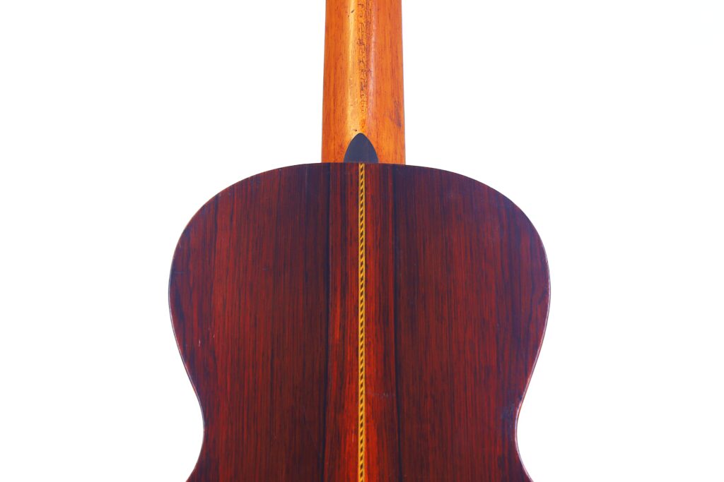 Nahaufnahme Der Rückseite Der Washburn 1894 Parlor Akustik Gitarre. Sie Zeigt Reiches Dunkles Holz Mit Einer Dekorativen Einlage In Der Mitte Und Einem Nach Oben Reichenden Holzhals, Alles Vor Einem Weißen Hintergrund.