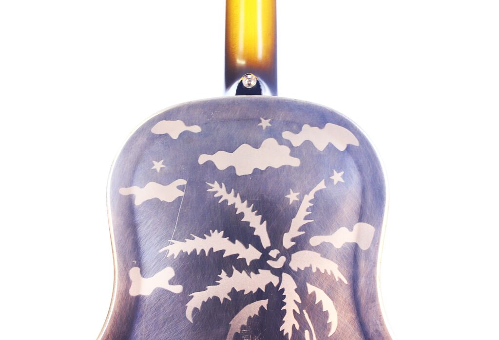 Die National Reso-Phonic Style O 2009 Akustik Gitarre Hat Einen Hölzernen Boden, Auf Dem Eine Palme, Wolken Und Sterne Eingraviert Sind, Von Hinten Gesehen Mit Dem Sich Erhebenden Hals Vor Einem Weißen Hintergrund.