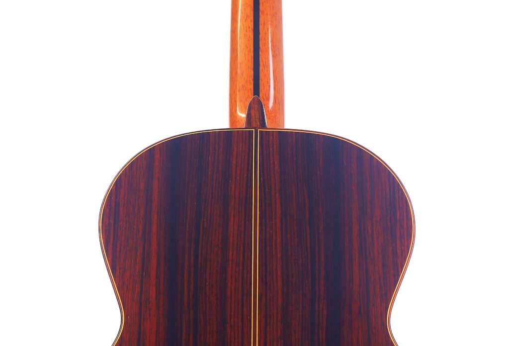 Die Rückseite Der José Ramírez Rb-A 636 Klassische Gitarre Hat Eine Polierte Holzoberfläche Mit Einer Ausgeprägten Mittelnaht, Vertikalen Maserungen Und Dem Oben Sichtbaren Hals.