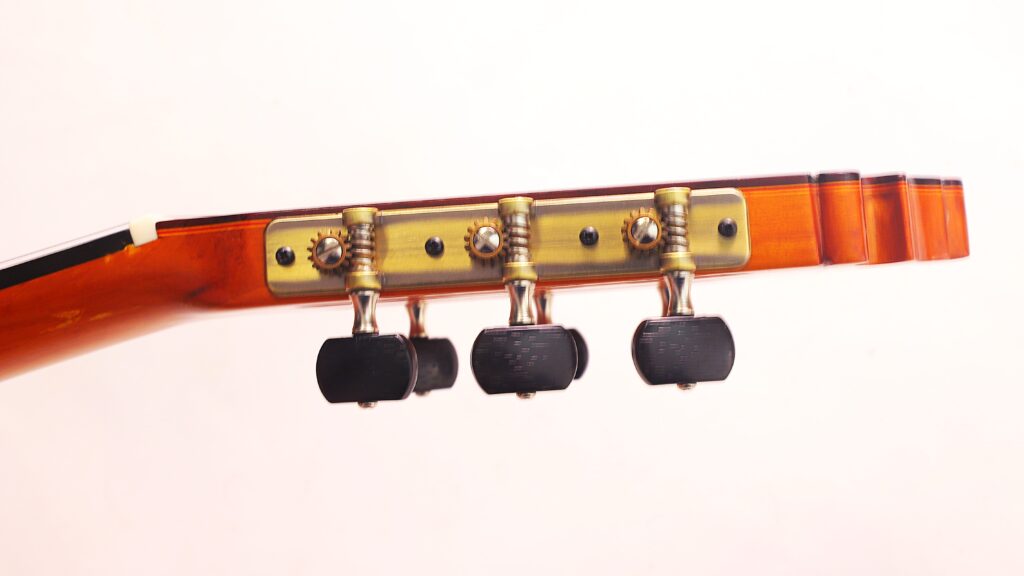 Nahaufnahme Der Kopfplatte Der Graciliano Perez 2025 Flamenco-Gitarre Mit Drei Schwarzen Stimmwirbeln Und Metallmechaniken Vor Einem Hellen Hintergrund.