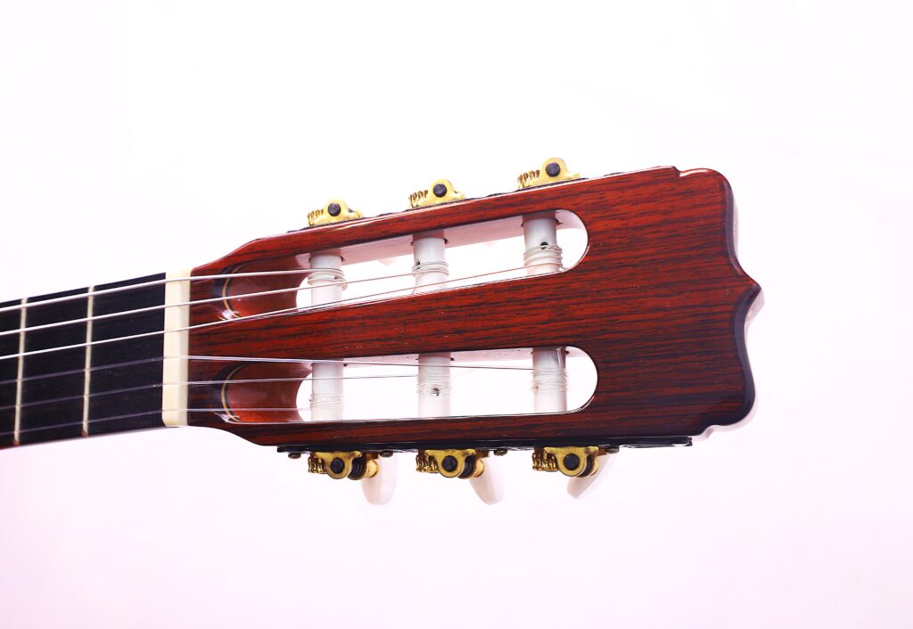 Nahaufnahme Der Kopfplatte Der José Ramírez Rb-A 636 Klassische Gitarre. Hervorzuheben Sind Die Stimmwirbel, Die Saiten Und Die Holzoberfläche Vor Einem Schlichten Weißen Hintergrund.