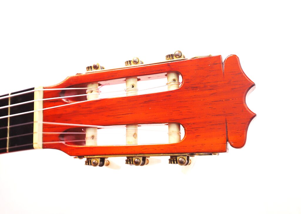 Nahaufnahme Der Kopfplatte Einer Faustino Conde Flamenco-Gitarre Von Hermanos Conde Aus Dem Jahr 1983 Mit Sechs Stimmwirbeln (Drei Pro Seite) Und Nylonsaiten Vor Weißem Hintergrund.