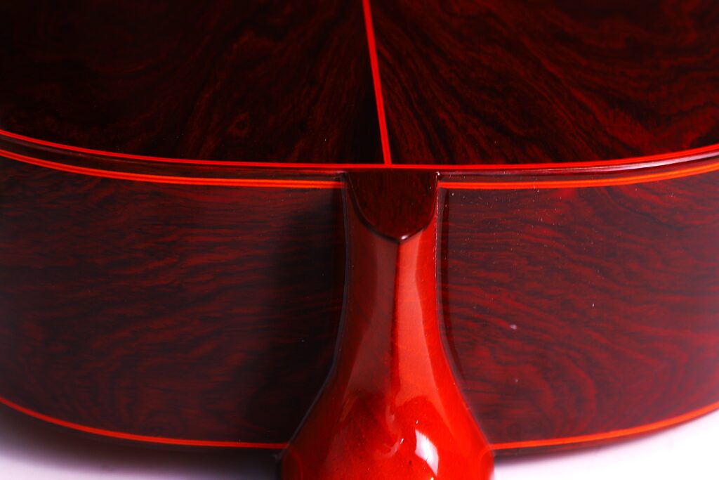 Nahaufnahme Des Bodens Und Des Halses Einer Hermanos Conde 1990 Paco De Lucia Special Flamenco Gitarre. Hervorzuheben Sind Die Polierte Rot-Braune Holzmaserung, Die Glänzende Oberfläche Und Die Rote Einfassung Entlang Der Kanten.