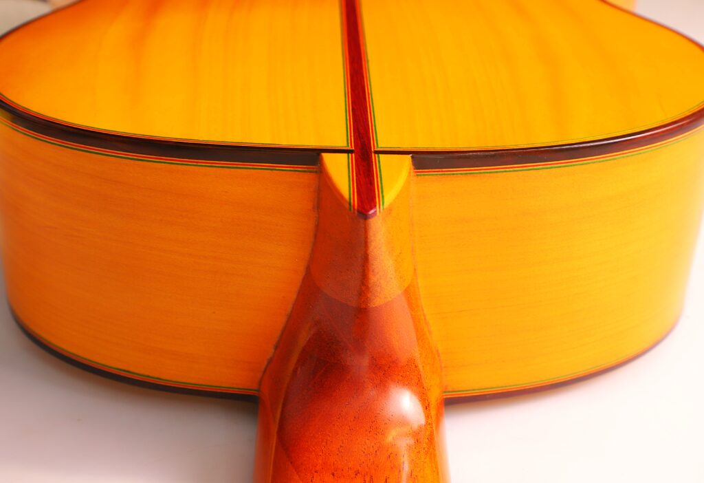 Nahaufnahme Der Graciliano Perez 2025 Flamenco-Gitarre. Hervorzuheben Sind Die Hölzerne Halsverbindung Und Der Glänzende, Helle Boden Und Die Zargen, Die Von Fachmännischer Handwerkskunst Und Einer Glatten Oberfläche Zeugen.