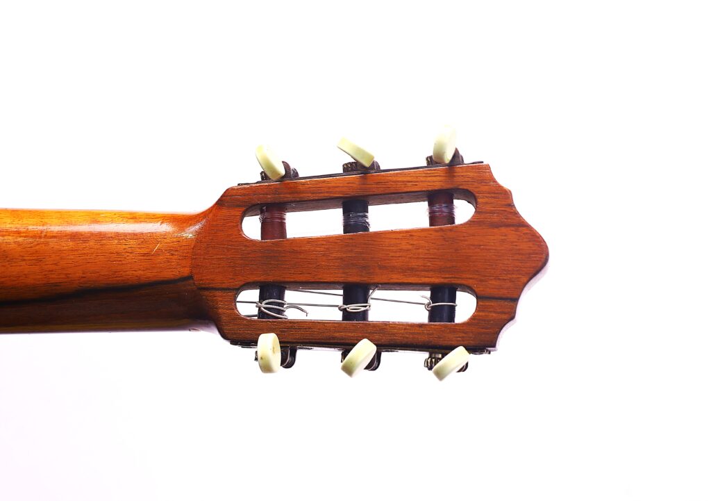 Nahaufnahme Der Kopfplatte Der Klassischen Gitarre Von Julián Gómez Ramírez Aus Dem Jahr 1933 Mit Hölzernen Stimmwirbeln Und Weißen Stimmschlüsseln, Fotografiert Auf Weißem Hintergrund.