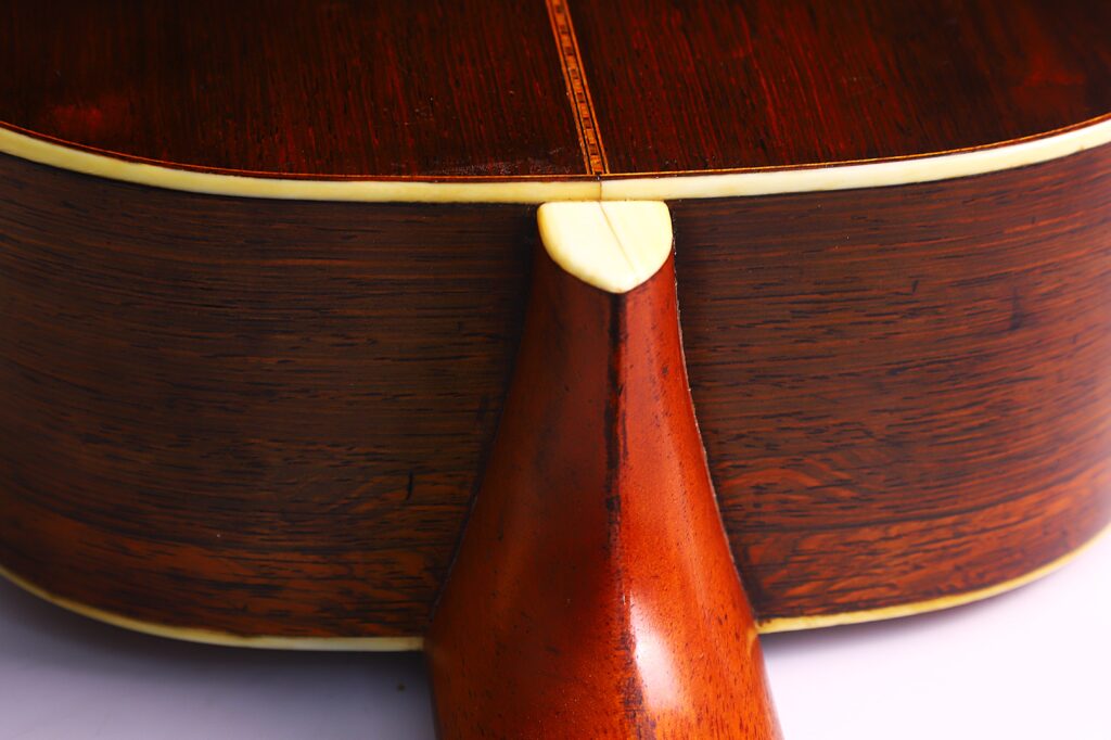 Nahaufnahme Des Bodens Und Des Halses Der Martin 0-30 1917 Akustik-Gitarre. Hervorzuheben Sind Die Satte Braune Holzmaserung, Das Cremefarbene Binding Und Die Glatt Polierte Oberfläche.