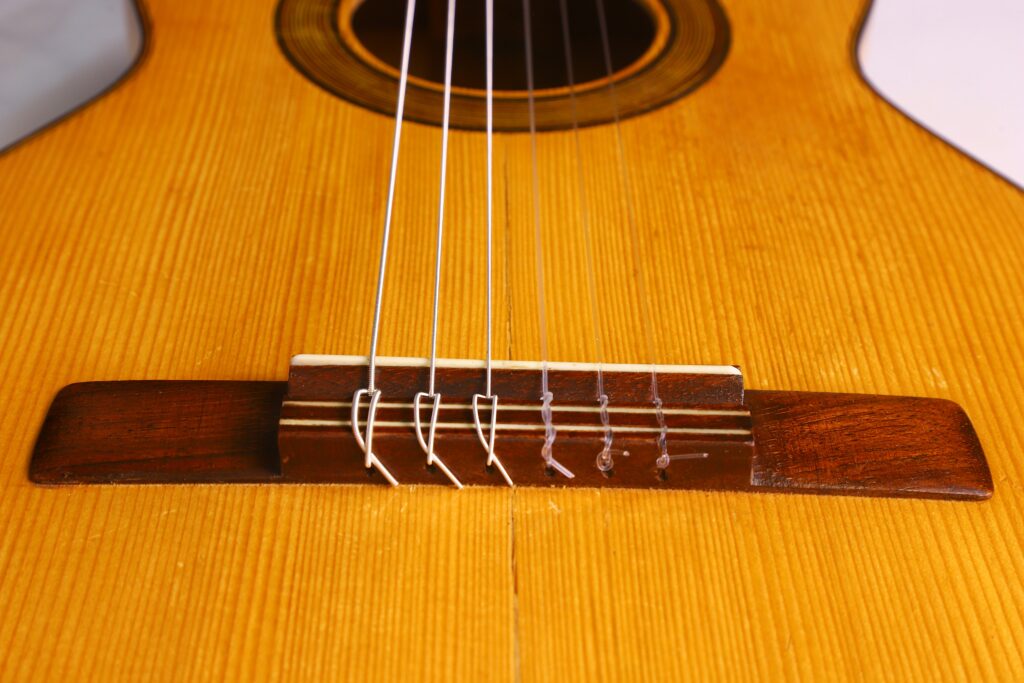 Jose Ramirez 1953 弗拉门戈吉他琴桥和琴弦特写。应着重强调复杂的木质纹理和琴弦固定在吉他琴身上的位置。.