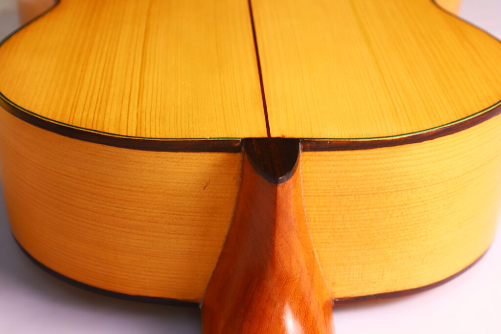 Nahaufnahme Der Oscar Orozco 2023 Santos Hernández Flamenco Gitarre. Hervorzuheben Ist Die Hals-Korpus-Verbindung Mit Sichtbarer Holzmaserung Und Polierter Oberfläche Auf Der Rückseite Der Akustikgitarre.