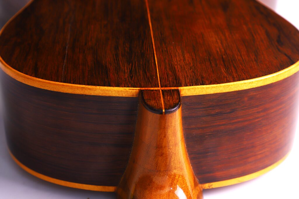 Nahaufnahme Des Bodens Und Des Halses Der Julián Gómez Ramírez 1933 Klassische Gitarre. Hervorzuheben Sind Die Reiche Braune Maserung Des Holzes, Die Glatte Polierte Oberfläche Und Die Hellen Verzierungen An Den Kanten.