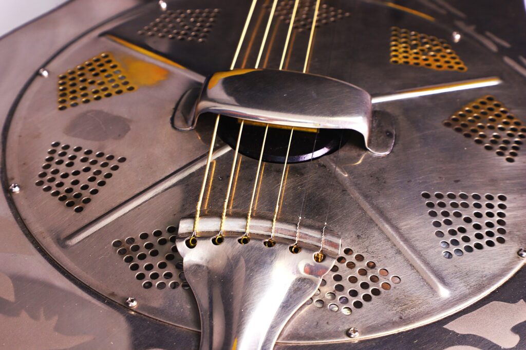 Nahaufnahme Der National Reso-Phonic Style O 2009 Akustik Gitarre. Hervorzuheben Sind Der Metallkorpus, Die Saiten, Die Gelochte Runde Abdeckplatte Und Die Charakteristische Glänzende Metalloberfläche.