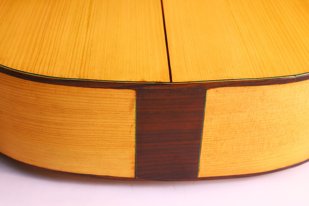 Nahaufnahme Der Rückseite Und Der Seite Der Oscar Orozco 2023 Santos Hernández Flamenco-Gitarre. Hervorzuheben Ist Die Helle Holzmaserung Des Korpus Mit Einem Vertikalen Dunklen Holzstreifen In Der Mitte.