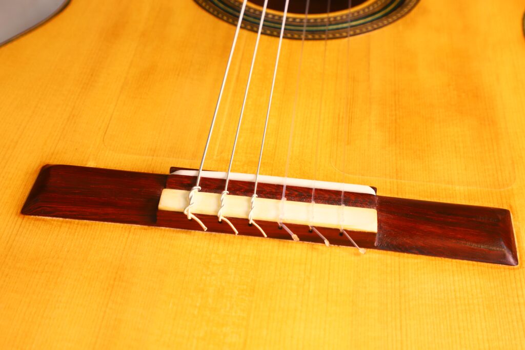 Nahaufnahme Der Oscar Orozco 2023 Santos Hernández Flamenco-Gitarre Mit Steg Und Saiten, Hervorhebung Des Holzkorpus, Des Sattels Und Eines Teils Des Schalllochs.