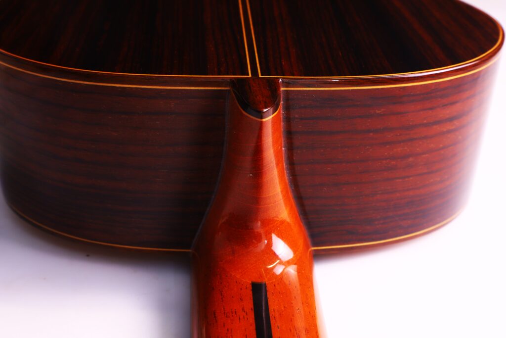 Nahaufnahme Des Bodens Und Des Halses Der José Ramírez Rb-A 636 Klassische Gitarre Mit Poliertem Holz Mit Dunklen Und Hellen Maserungen Und Einer Glänzenden Oberfläche.