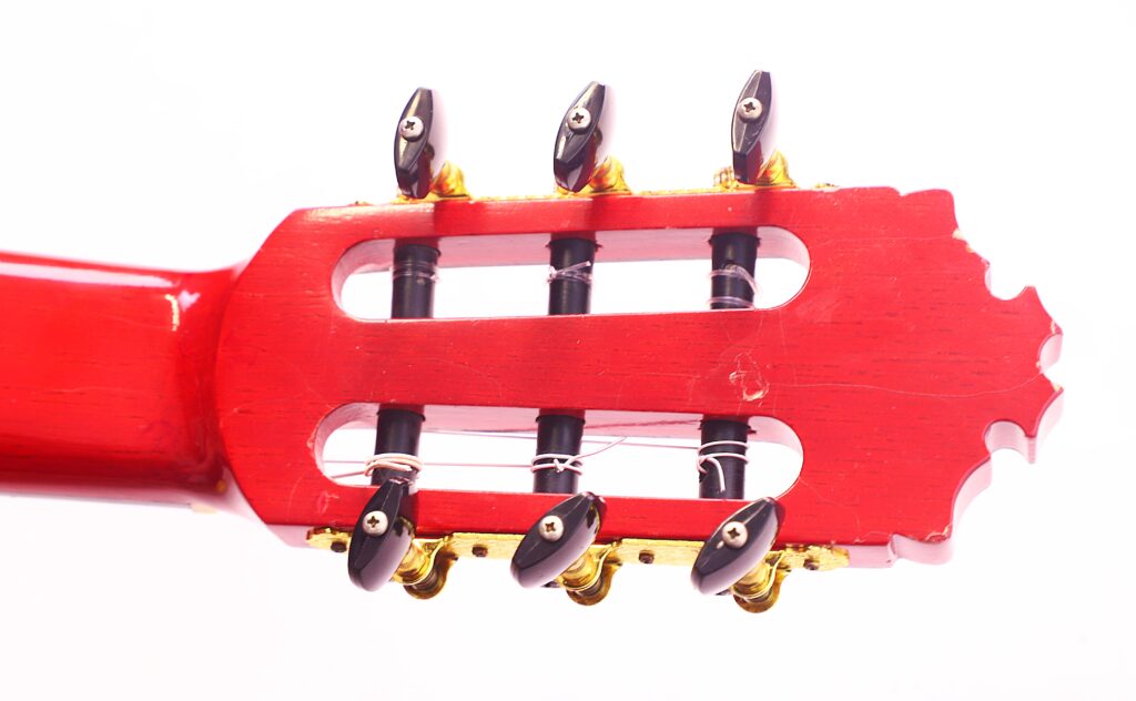 Nahaufnahme Der Stimmwirbel An Der Kopfplatte Einer Manuel Guillena 2017 Blanca Flamenco-Gitarre Mit Sechs Schwarzen Mechaniken Und Goldener Hardware Auf Weißem Hintergrund.