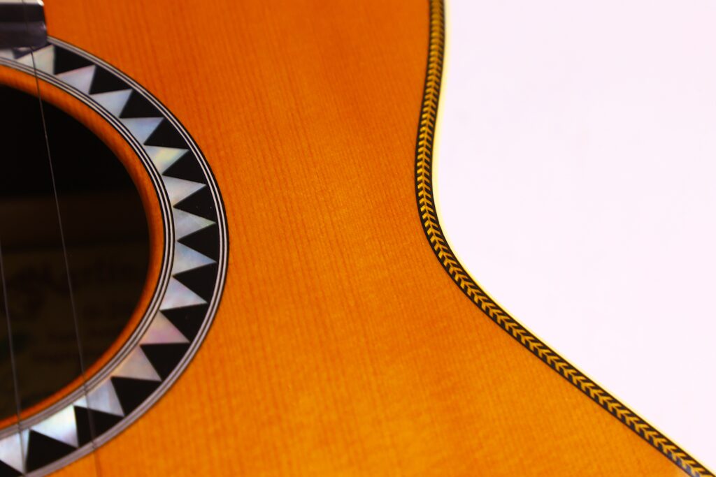 Nahaufnahme Der Martin 0-28 Ian Anderson Akustik Gitarre Mit Geometrischer Schwarz-Weißer Rosette Um Das Schallloch Und Detaillierter Fischgräteneinlage Entlang Der Kante Des Holzkorpus.