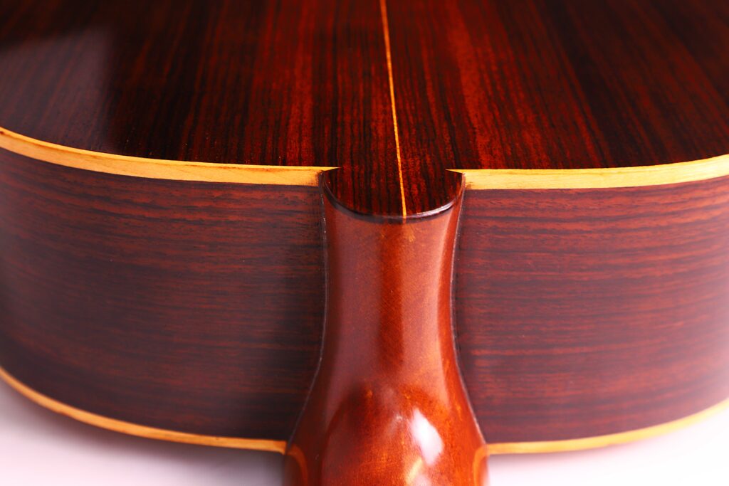 Nahaufnahme Des Halsgelenks Einer Vicente Tatay Alabau 1920 Klassische Gitarre. Hervorzuheben Sind Die Polierte Holzmaserung, Der Dunkelbraune Boden Und Die Hellgelbe Einfassung Entlang Der Kanten.