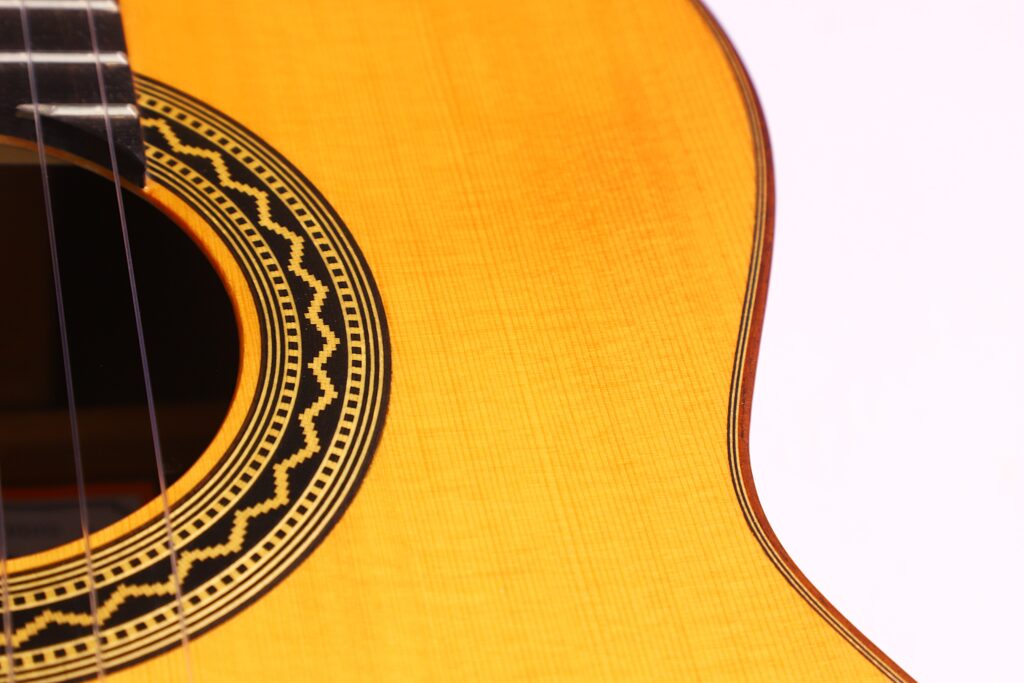 Nahaufnahme Des Korpus Der José Ramírez Rb-A 636 Klassische Gitarre. Hervorzuheben Sind Die Filigrane Rosette Um Das Schallloch, Die Feine Holzmaserung Und Ein Teil Des Halses Und Der Saiten, Die Links Zu Sehen Sind.