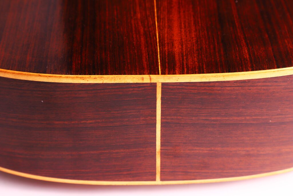 Nahaufnahme Des Bodens Und Der Seite Der Vicente Tatay Alabau 1920 Klassische Gitarre, Mit Reicher Dunkler Holzmaserung, Hellem Einband Und Einer Mittelnaht.