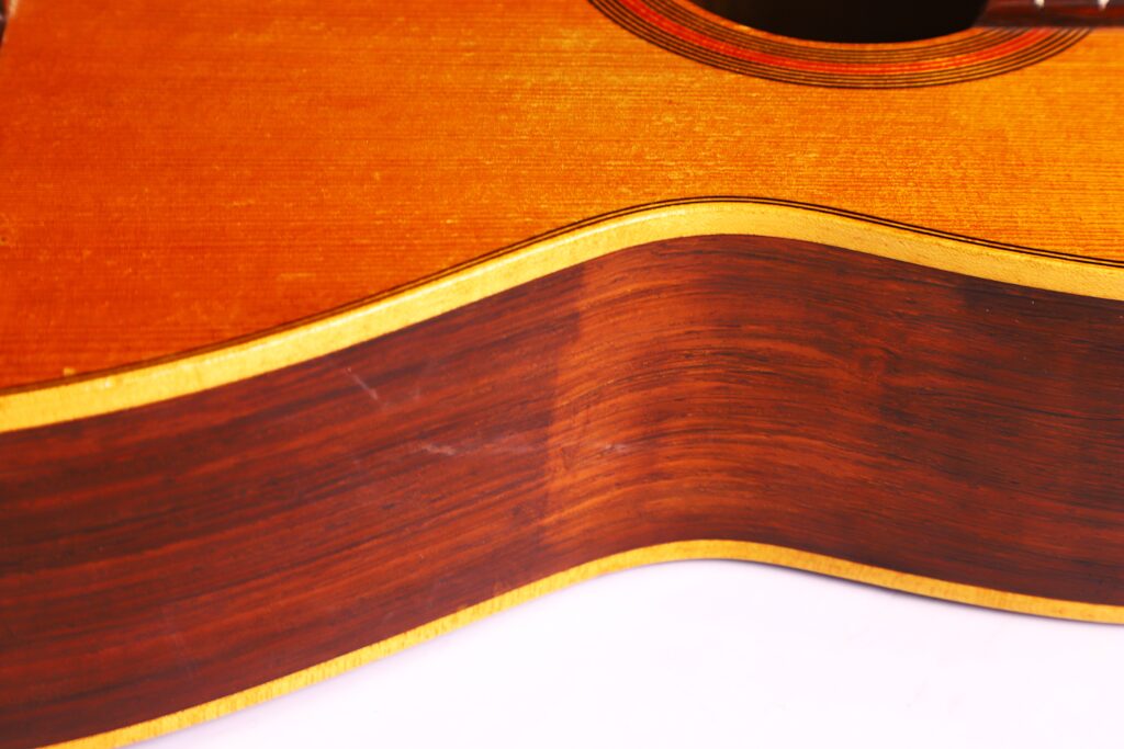 Nahaufnahme Der Julián Gómez Ramírez 1933 Klassische Gitarre. Hervorzuheben Sind Die Holzmaserung Und Der Kontrast Zwischen Der Dunkelbraunen Seite Und Der Helleren, Orangefarbenen Decke.