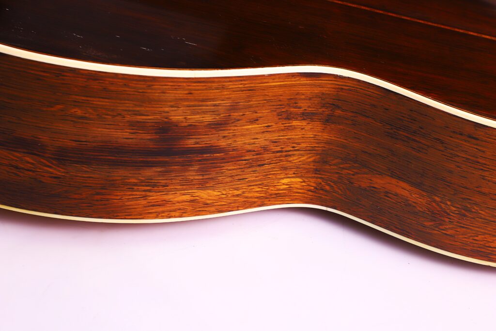 Nahaufnahme Der Polierten Holzseite Einer Martin 0-30 1917 Akustik Gitarre Mit Cremefarbenem Binding, Die Die Schöne Holzmaserung Der Gitarre Vor Einem Hellen Hintergrund Zur Geltung Bringt.