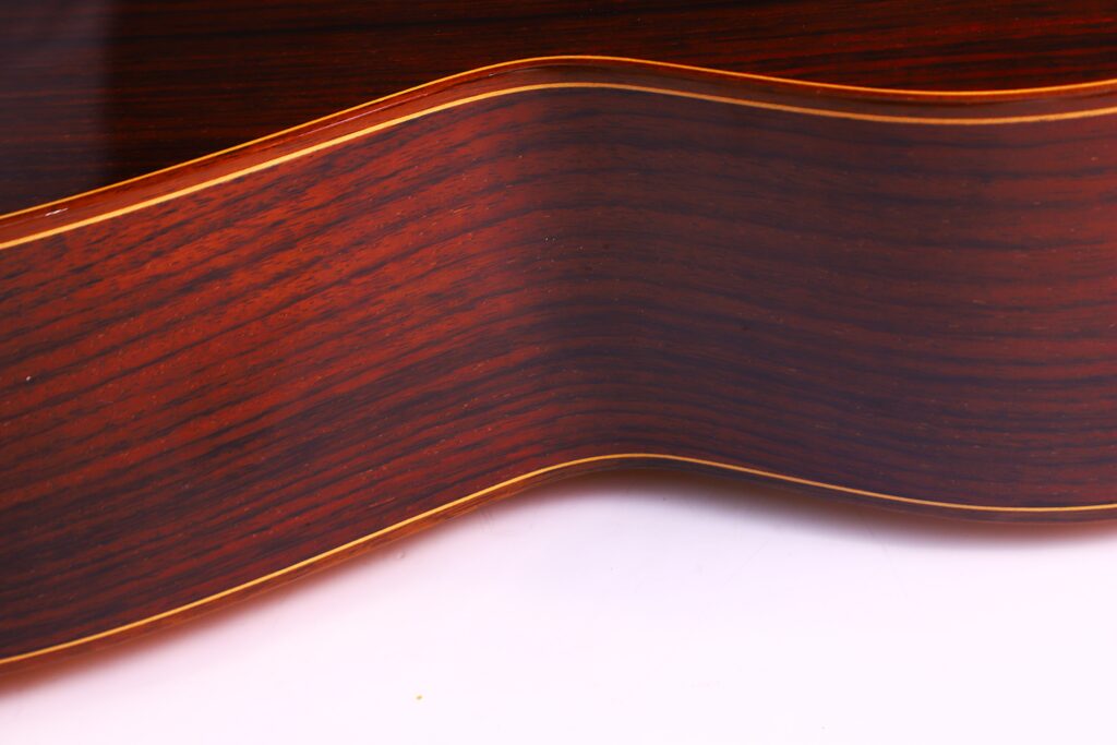 Nahaufnahme Der José Ramírez Rb-A 636 Klassische Gitarre. Hervorzuheben Ist Der Gewölbte, Polierte Holzkorpus Mit Dunkelbrauner Und Rötlicher Maserung Und Dünner, Heller Bindung.