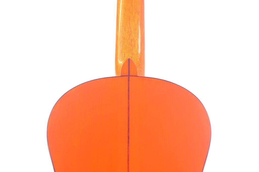 Nahaufnahme Des Bodens Einer Pedro Fernández Luque 2020 Blanca Flamenco-Gitarre. Hervorzuheben Sind Die Glänzende Orangefarbene Holzoberfläche Und Die Stelle, An Der Der Hals Auf Den Korpus Trifft.