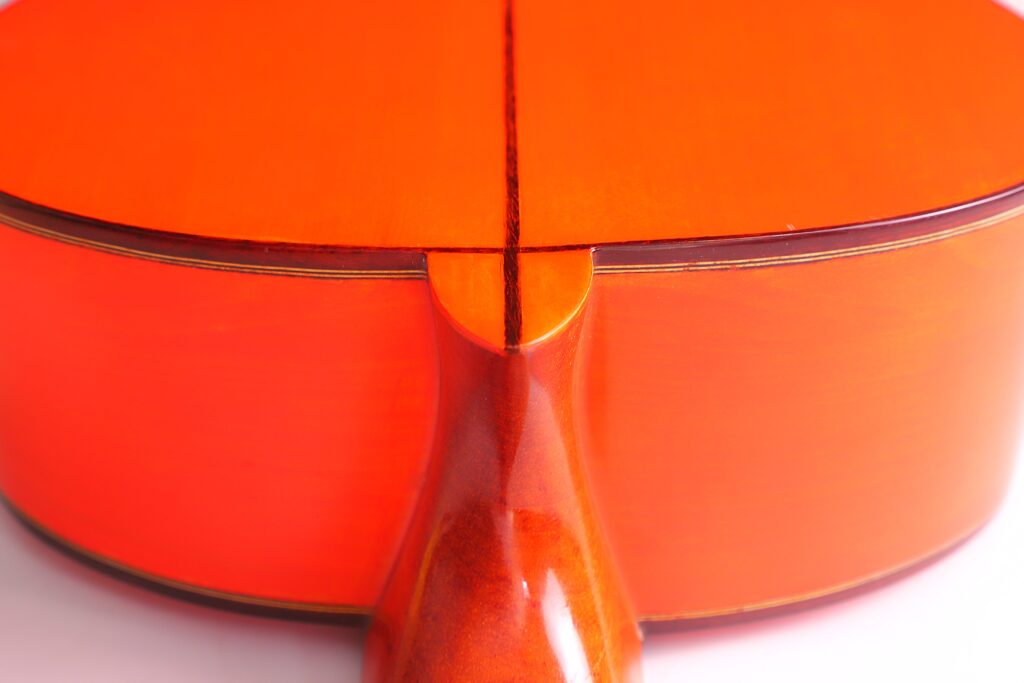 Nahaufnahme Des Bodens Einer Pedro Fernández Luque 2020 Blanca Flamenco-Gitarre. Hervorzuheben Ist Die Stelle, An Der Der Hals Auf Den Korpus Trifft, Mit Sichtbarer Holzmaserung Und Glänzender Oberfläche.