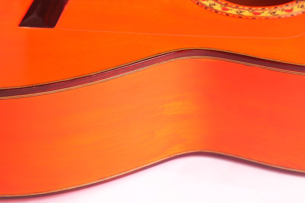 Nahaufnahme Der Seite Und Der Oberseite Der Pedro Fernández Luque 2020 Blanca Flamenco-Gitarre, Die Die Wölbung Des Korpus Und Die Dekorativen Details In Der Nähe Des Schalllochs Vor Einem Weißen Hintergrund Hervorhebt.