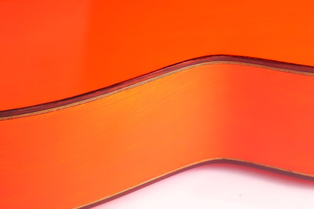 Nahaufnahme Der Gewölbten Seite Einer Pedro Fernández Luque 2020 Blanca Flamenco-Gitarre, Die Die Glatte Holzmaserung Und Die Dunklen Verzierungen Vor Einem Hellen Hintergrund Hervorhebt.