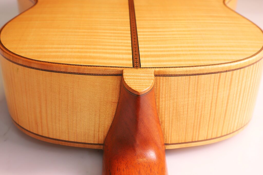 Nahaufnahme Des Bodens Und Der Halsverbindung Der Mario Gropp 2020 Klassische Gitarre. Hervorzuheben Sind Die Helle Holzmaserung, Der Dekorative Mittelstreifen Und Der Sanfte Übergang Vom Korpus Zum Hals.