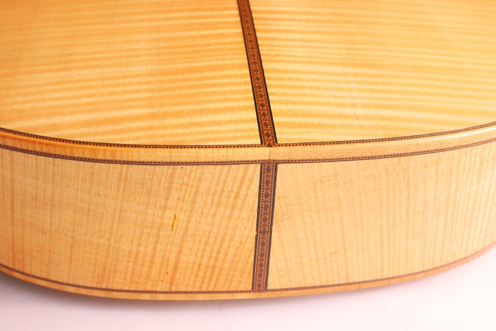 Nahaufnahme Der Mario Gropp 2020 Klassische Gitarre. Hervorzuheben Sind Das Helle Holz, Die Feinen Maserungen Und Die Detaillierten Ziereinlagen Entlang Der Nähte.