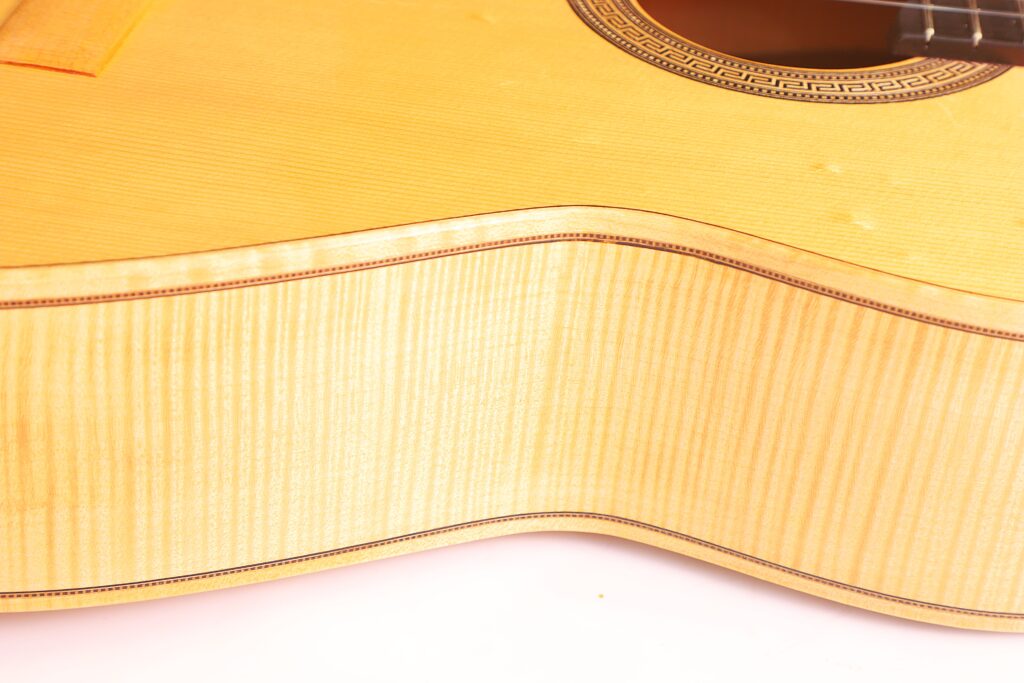 Nahaufnahme Des Korpus Der Mario Gropp 2020 Klassische Gitarre. Hervorzuheben Sind Die Helle Holzmaserung, Die Dekorativen Einfassungen Und Die Gemusterte Umrandung Des Schalllochs.