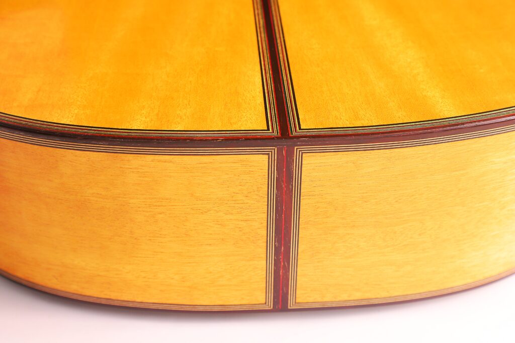 Nahaufnahme Der Rückseite Und Der Seite Der Michael Wichmann 2017 Simplicio Klassische Gitarre, Die Das Helle Holz, Die Dunklen Zierlinien Und Die Präzise Handwerkskunst Hervorhebt.