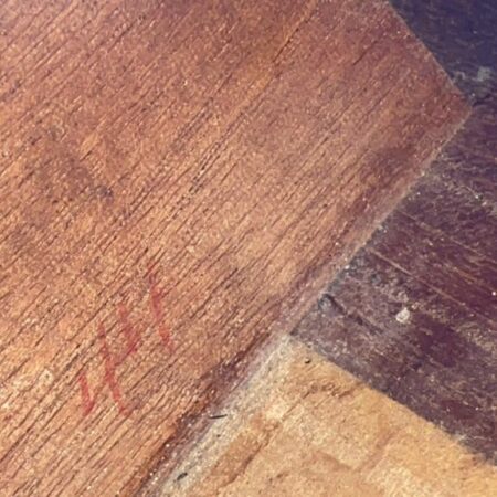 Eine Nahaufnahme Der Hölzernen Oberfläche Der Gibson L-00 1934 Akustik Gitarre Zeigt Ineinandergreifende Bretter Mit Einem Abgenutzten, Strukturierten Aussehen Und Einer Verblassten Roten Markierung, Die An &Quot;444&Quot; Oder &Quot;111&Quot; Auf Der Linken Seite Erinnert.