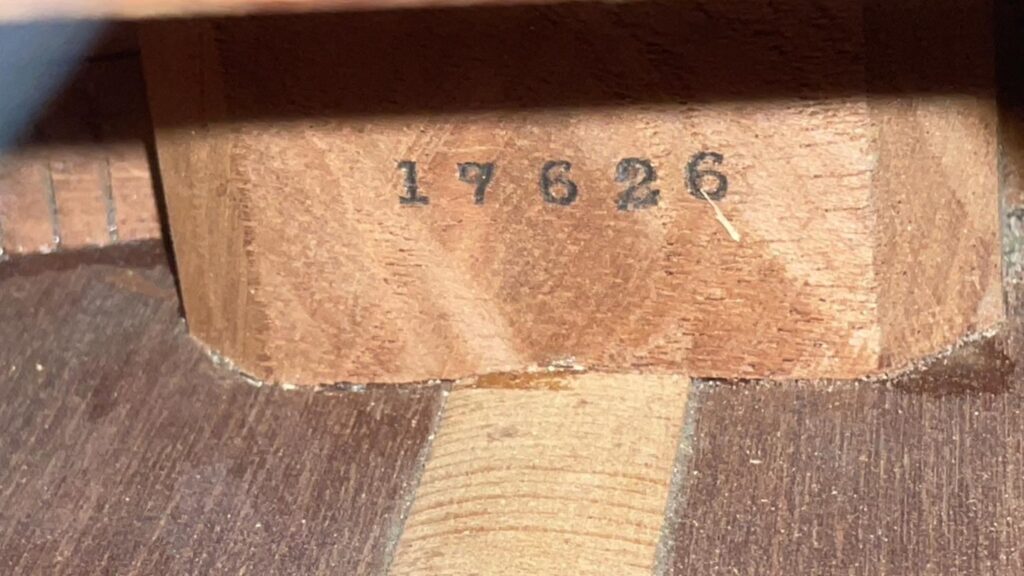Eine Nahaufnahme Einer Martin 00-18 1922 Akustik Gitarre Zeigt Die Nummer 17626 In Schwarzer Tinte Auf Einem Helleren Holzblock, Mit Sichtbarer Holzmaserung.