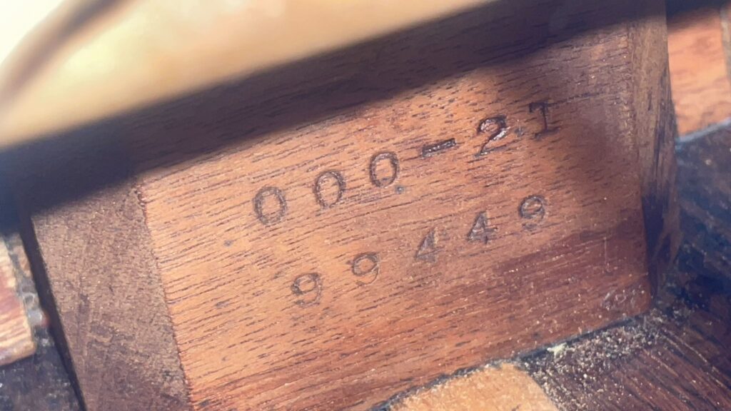 Nahaufnahme Der Holzoberfläche Einer Martin 000-21 Akustikgitarre Aus Dem Jahr 1947, Die Die Gestempelte Modellnummer &Quot;000-21&Quot; Über Der Seriennummer &Quot;98449&Quot; Zeigt.