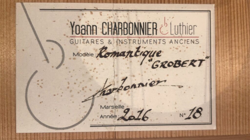 Ein Etikett Für Die Grobert Romantikgitarre 2016 Von Yoann Charbonnier, Mit Handschriftlichen Angaben: Modèle Romantique Grobert, 2016, Marseille, Und Nummer 18. Auf Der Linken Seite Ist Ein Teil Des Umrisses Einer Gitarre Zu Sehen.