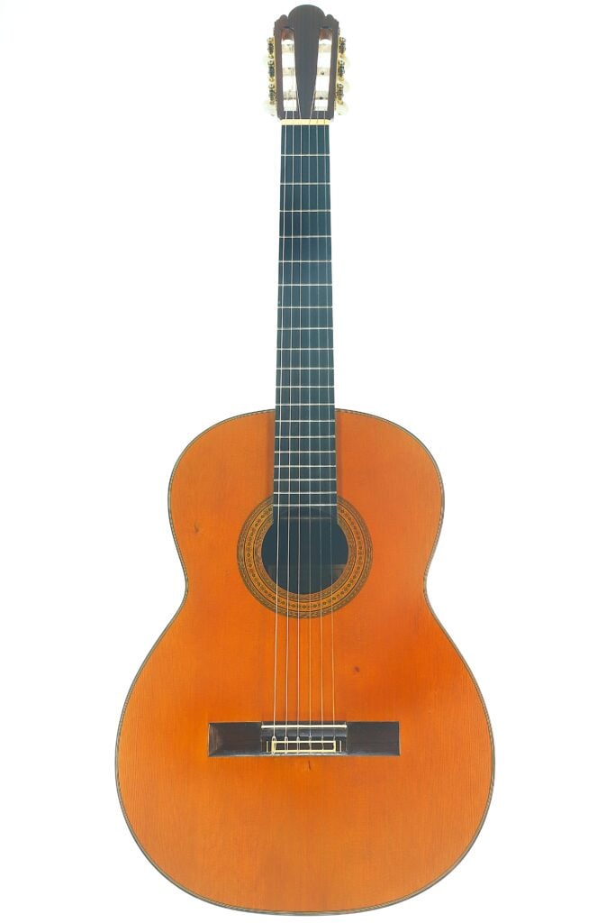 Die „Ignacio Fleta 1992 Klassische Gitarre“, eine klassische Akustikgitarre mit Holzkorpus, schwarzem Griffbrett und Nylonsaiten, wird vor einem weißen Hintergrund präsentiert. Die „Ignacio Fleta 1992 Klassische Gitarre“, eine klassische Akustikgitarre mit Holzkorpus, schwarzem Griffbrett und Nylonsaiten, wird vor einem weißen Hintergrund präsentiert.