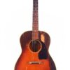Die Gibson LG-2 1946 Akustik Gitarre hat eine Sunburst-Lackierung mit sichtbaren Kratzern und abgenutzten Stellen, ein dunkles Schlagbrett und sechs Saiten. Sie ist vor einem weißen Hintergrund fotografiert. Die Gibson LG-2 1946 Akustik Gitarre hat eine Sunburst-Lackierung mit sichtbaren Kratzern und abgenutzten Stellen, ein dunkles Schlagbrett und sechs Saiten. Sie ist vor einem weißen Hintergrund fotografiert.