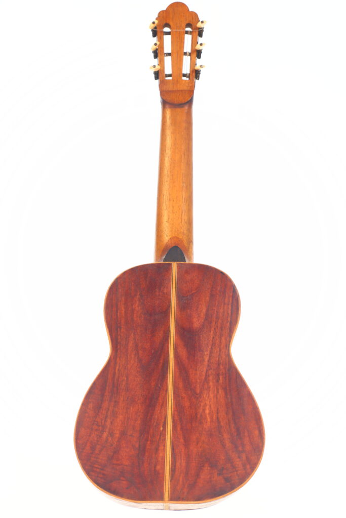 Die Vicente Carillo 1925 Terz Gitarre wird von hinten gezeigt, wobei der polierte Holzkorpus mit sichtbarer Maserung und der glatte Hals hervorgehoben werden, fotografiert vor einem weißen Hintergrund. Die Vicente Carillo 1925 Terz Gitarre wird von hinten gezeigt, wobei der polierte Holzkorpus mit sichtbarer Maserung und der glatte Hals hervorgehoben werden, fotografiert vor einem weißen Hintergrund.