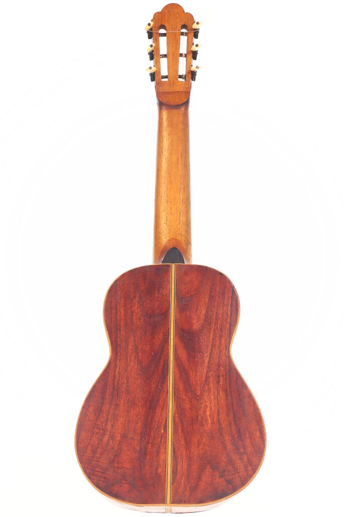 Rückansicht der Vicente Carillo 1925 Terz-Gitarre, die eine satte braune Holzoberfläche mit sichtbaren Holzmaserungen und Stimmwirbeln auf der Oberseite vor einem weißen Hintergrund aufweist. Rückansicht der Vicente Carillo 1925 Terz-Gitarre, die eine satte braune Holzoberfläche mit sichtbaren Holzmaserungen und Stimmwirbeln auf der Oberseite vor einem weißen Hintergrund aufweist.
