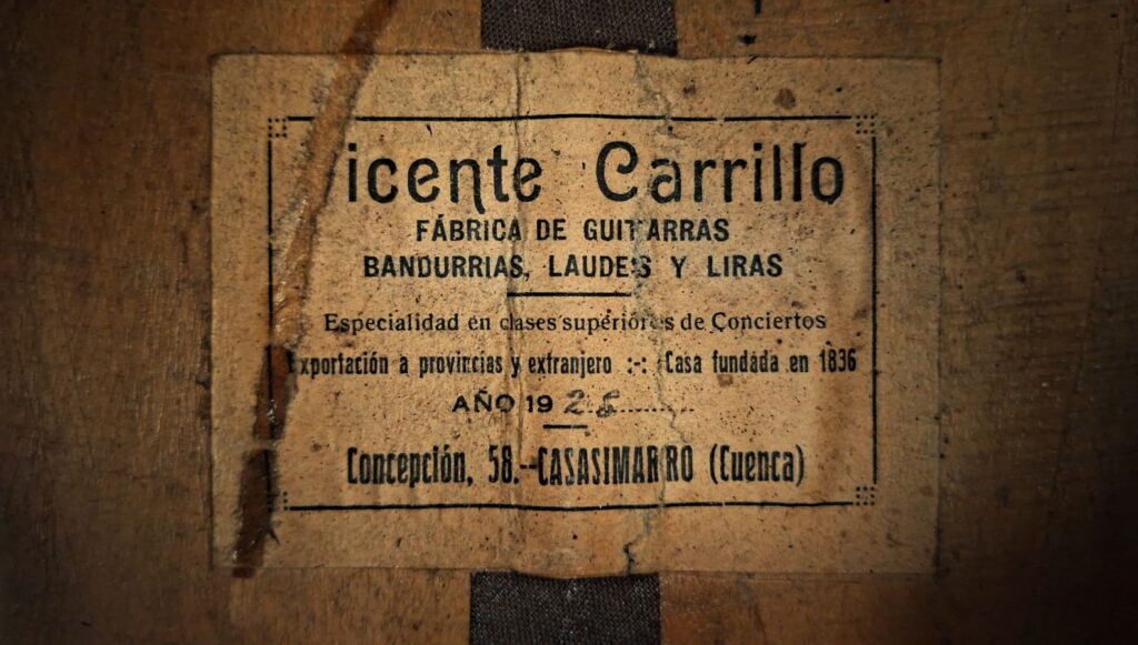 Im Inneren der Vicente Carillo 1925 Terz Gitarre, ein Vintage-Etikett liest: Vicente Carrillo, Fábrica de Guitarras, Bandurrias, Laudes y Liras, mit gealtertem Papier und verblasstem Text, der über einem dunklen Streifen auf dem Holz angebracht ist. Im Inneren der Vicente Carillo 1925 Terz Gitarre, ein Vintage-Etikett liest: Vicente Carrillo, Fábrica de Guitarras, Bandurrias, Laudes y Liras, mit gealtertem Papier und verblasstem Text, der über einem dunklen Streifen auf dem Holz angebracht ist.