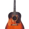 Eine Gibson J-45 1948 Akustik-Gitarre mit Sunburst-Lackierung, sichtbaren Gebrauchsspuren und Kratzern, abgerundeter Korpusform, sechs Saiten und weißen Wirbeln. Eine Gibson J-45 1948 Akustik-Gitarre mit Sunburst-Lackierung, sichtbaren Gebrauchsspuren und Kratzern, abgerundeter Korpusform, sechs Saiten und weißen Wirbeln.