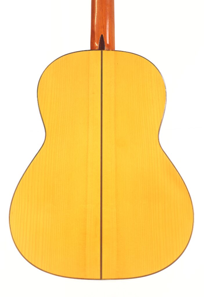 Rückansicht der Marcelino López Nieto 1959 Flamenco-Gitarre mit heller Holzoberfläche, dunkler Mittelnaht und glänzend braunem Hals, fotografiert vor einem weißen Hintergrund. Rückansicht der Marcelino López Nieto 1959 Flamenco-Gitarre mit heller Holzoberfläche, dunkler Mittelnaht und glänzend braunem Hals, fotografiert vor einem weißen Hintergrund.