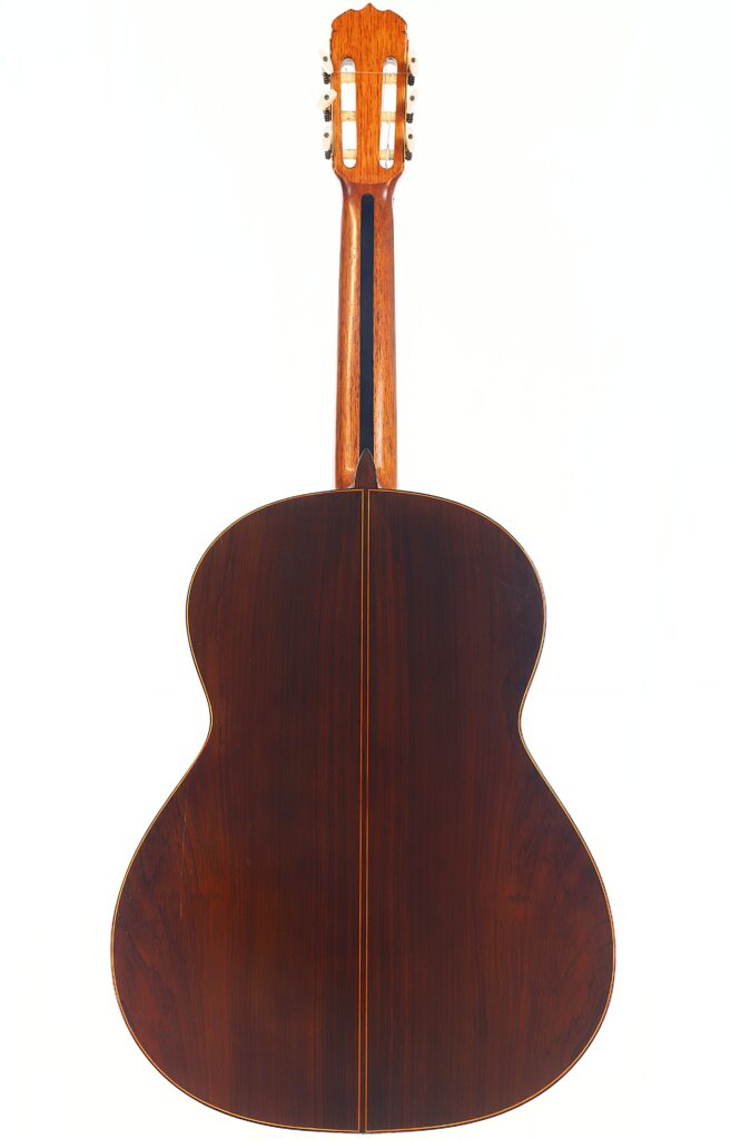 Die Rückansicht der Jose Ramirez 1a 1959 PB Klassische Gitarre zeigt den dunklen Holzkorpus, den helleren Holzhals und die sichtbaren Mechaniken, alles vor einem weißen Hintergrund fotografiert. Die Rückansicht der Jose Ramirez 1a 1959 PB Klassische Gitarre zeigt den dunklen Holzkorpus, den helleren Holzhals und die sichtbaren Mechaniken, alles vor einem weißen Hintergrund fotografiert.
