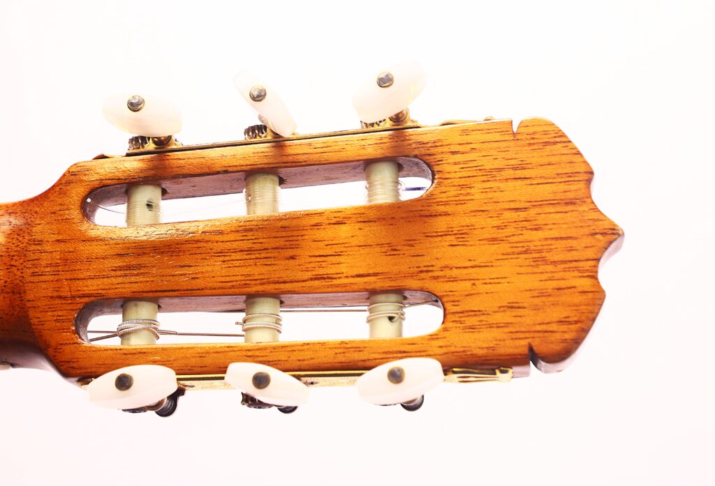 Nahaufnahme der Kopfplatte einer Jose Ramirez 1a 1959 PB Klassische Gitarre mit weißen Stimmwirbeln vor einem schlichten weißen Hintergrund. Nahaufnahme der Kopfplatte einer Jose Ramirez 1a 1959 PB Klassische Gitarre mit weißen Stimmwirbeln vor einem schlichten weißen Hintergrund.